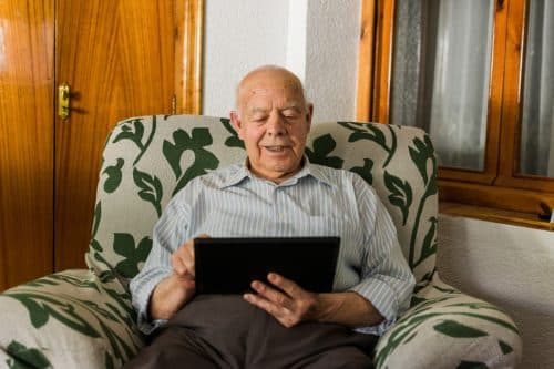 elderly-man-is-using-a-digital-tablet-at-home-comp